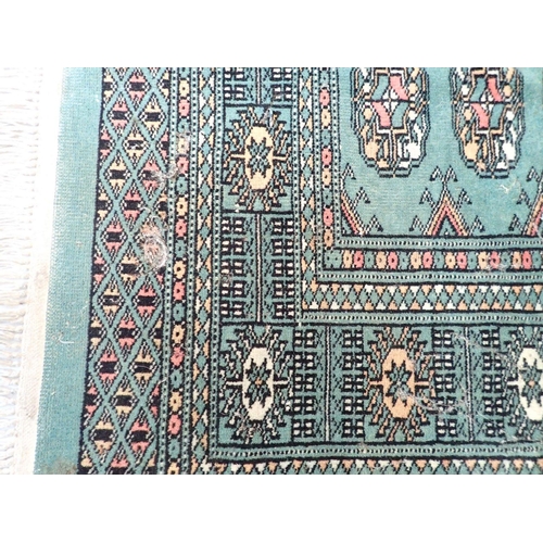 886 - A green ground Turkoman rug with double row of guls 146 x 98cm