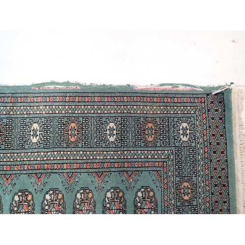 886 - A green ground Turkoman rug with double row of guls 146 x 98cm