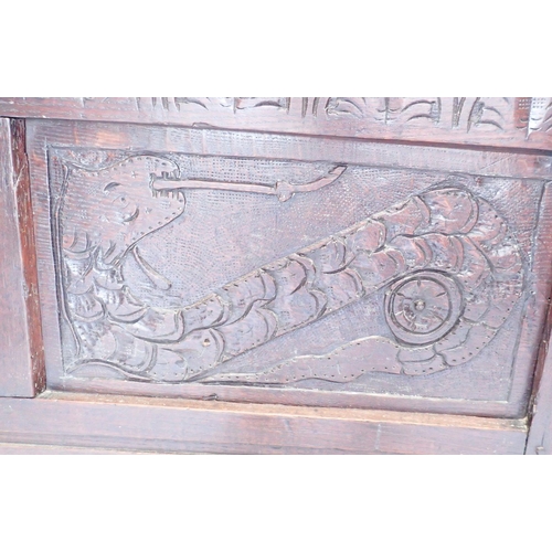 925 - An antique oak mule chest with foliate lunette frieze over two dragon carved panels and two foliate ... 