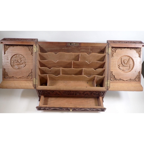 940 - An Indian hardwood slope front correspondence box carved all over dragon and floral decoration, with... 