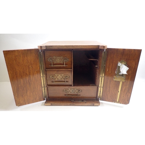 945 - A Victorian oak smokers cabinet in the form of a safe, with fitted interior and key, 30 x 23 x 32cm