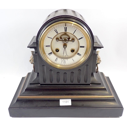 1101 - A Victorian black slate mantel clock with visible escapement and enamel dial with lion masks to side... 