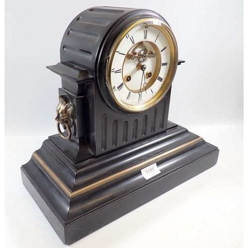 1101 - A Victorian black slate mantel clock with visible escapement and enamel dial with lion masks to side... 