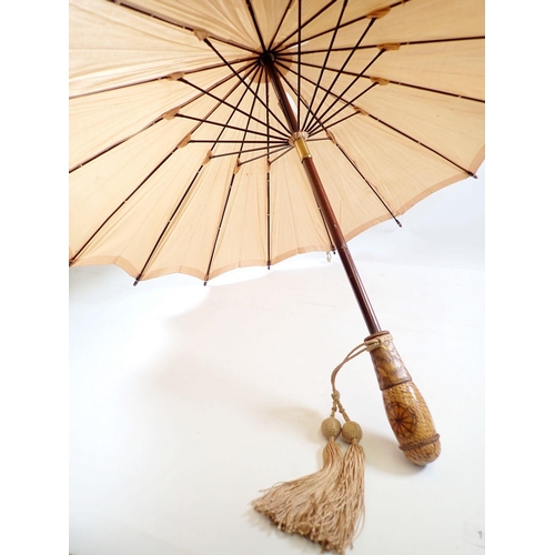 1236 - A Japanese peach silk parasol with carved wooden handle and terminal, 58cm long