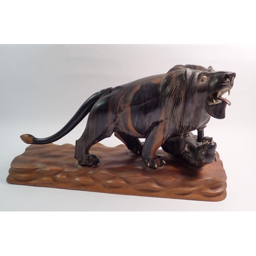 1245 - An oriental rosewood carved lion attacking a tiger, 46cm long