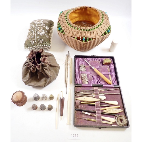 1252 - A wicker work basket, a Victorian beadwork pin cushion and an old sewing kit and contents