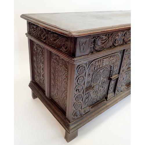 1280 - A large 17th oak coffer with carved triple panelled front and foliage carved sides, 157cm wide