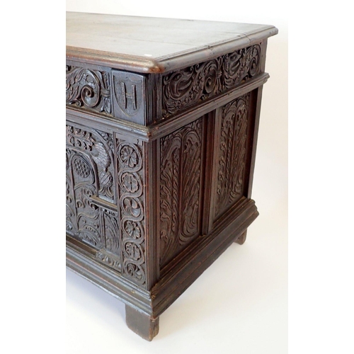 1280 - A large 17th oak coffer with carved triple panelled front and foliage carved sides, 157cm wide