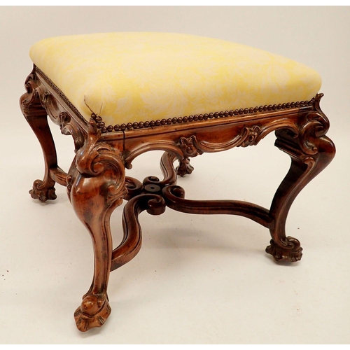 1285 - A Victorian square footstool upholstered in yellow and with scrollwork apron all on four hipped and ... 