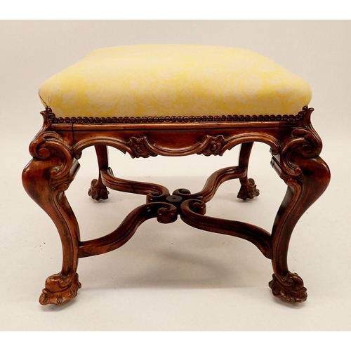 1285 - A Victorian square footstool upholstered in yellow and with scrollwork apron all on four hipped and ... 