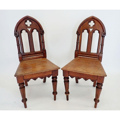 1286 - A pair of Victorian oak Gothic arch back hall chairs