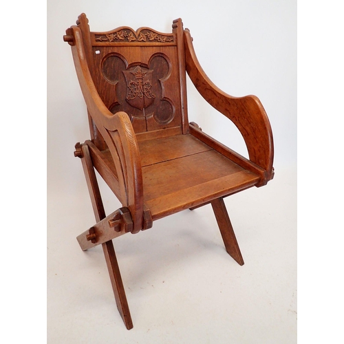 1293 - An oak Glastonbury chair of pegged construction with carved coronet to back