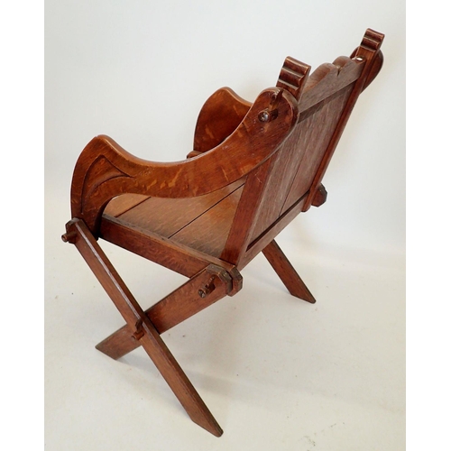 1293 - An oak Glastonbury chair of pegged construction with carved coronet to back