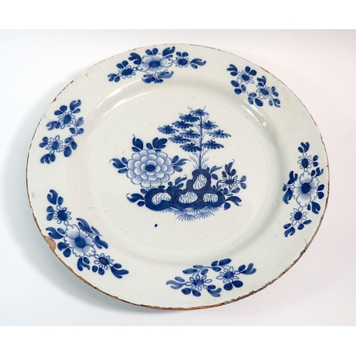 131 - An 18th century Delft charger painted floral sprays, 35cm diameter