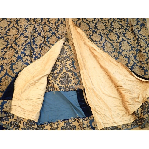 1317 - A pair of vintage blue and gilt foliate curtains with velvet banding, 216cm wide x 267cm drop