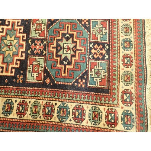 1347 - A Turkoman rug with three geometric medallions on a blue ground 161 x 98cm