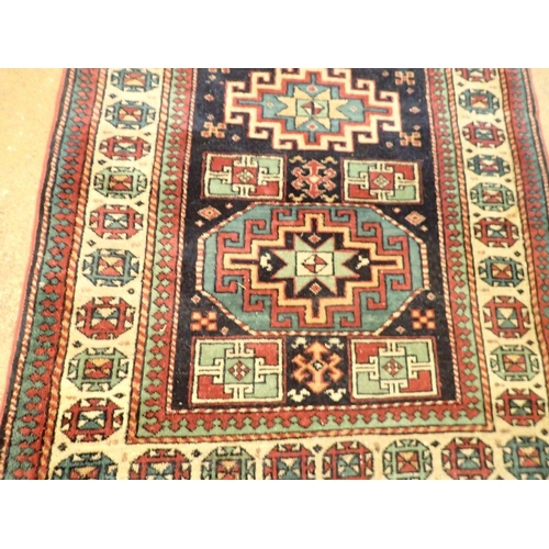 1347 - A Turkoman rug with three geometric medallions on a blue ground 161 x 98cm