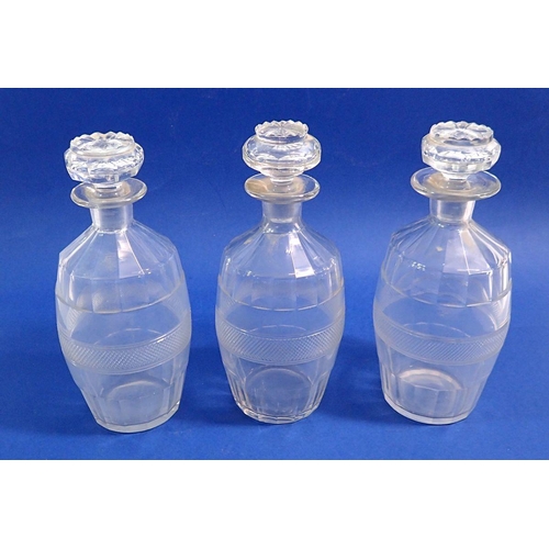 176 - A set of three facet cut small glass decanters, 20cm tall