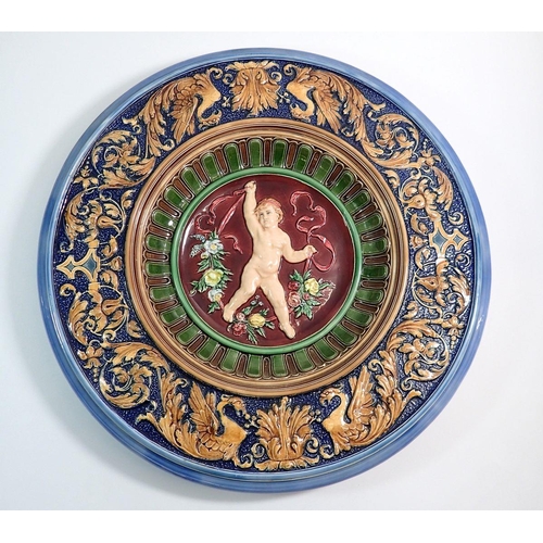 2 - An Italian maiolica large charger decorated putti and flowers with two fish marks to reverse, 45cm d... 