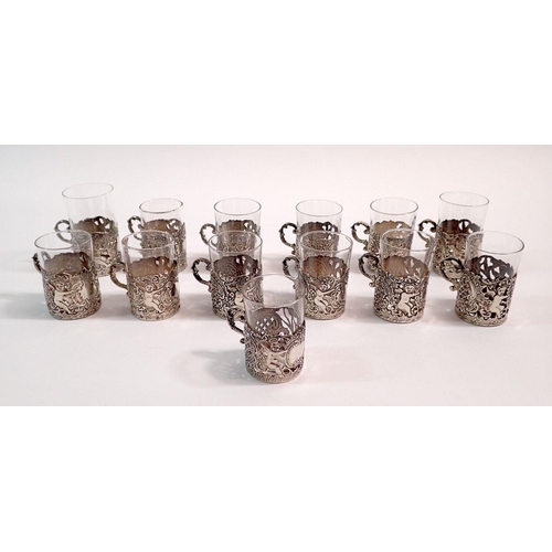 235 - A set of twelve Indian white metal liquor glass holders with pierced cherub and scrollwork decoratio... 