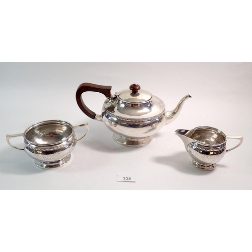 338 - A silver three piece tea service with ribbon border, by A. E. Jones, Birmingham 1922, 840g