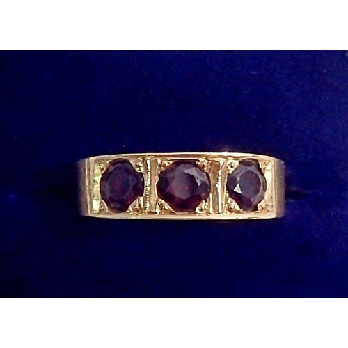 349 - A 14kt gold ring inset three garnets, size N to O, 6.3g