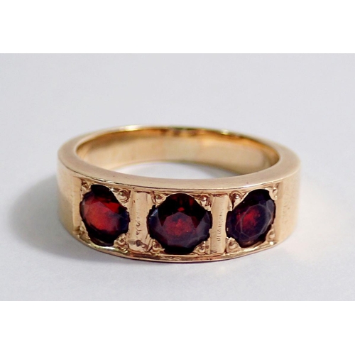 349 - A 14kt gold ring inset three garnets, size N to O, 6.3g