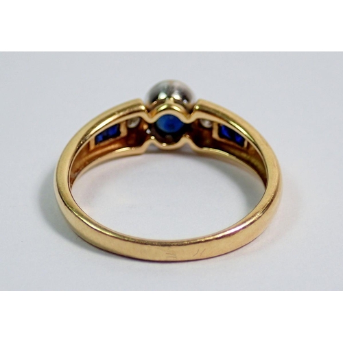 364 - An 18 carat gold modern ring set sapphire flanked  by two diamonds on baguette cut sapphire shoulder... 