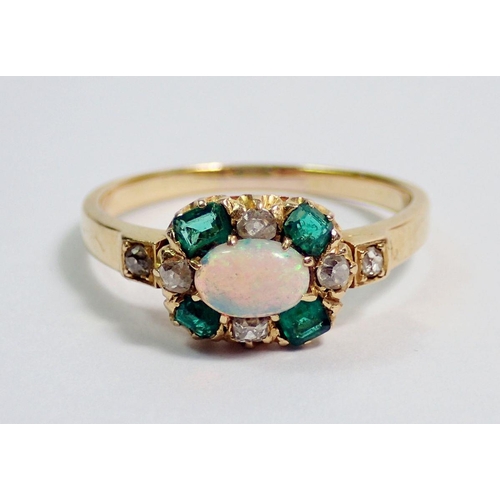 381 - A gold ring set oval opal within emerald and diamond surround, unmarked but thought to be 18 carat, ... 