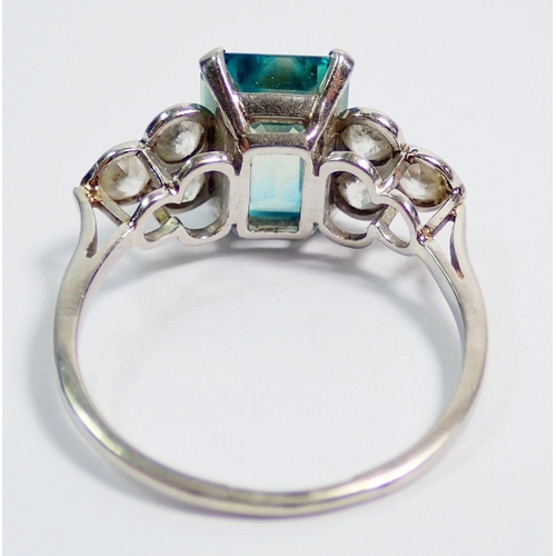 389 - An Art Deco style 18 carat white gold ring set  blue tourmaline flanked by six diamonds, size Q