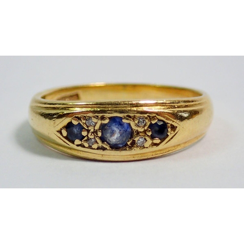 392 - An 18 carat gold ring set three sapphires and four chip diamonds, size J, 3.5g