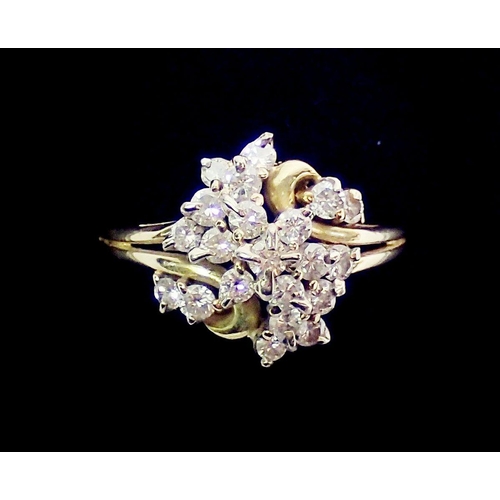 394 - An 18 carat gold ring with twenty one diamonds set in asymmetrical bow design, size T, 5.7g