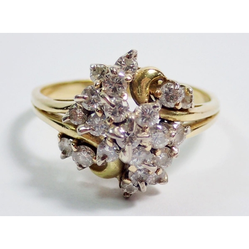 394 - An 18 carat gold ring with twenty one diamonds set in asymmetrical bow design, size T, 5.7g