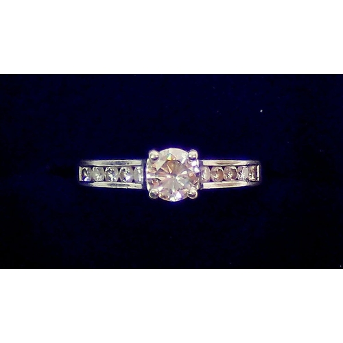 427 - A platinum ring set central diamond flanked by ten diamonds inset to shoulders, size M, 5.5g