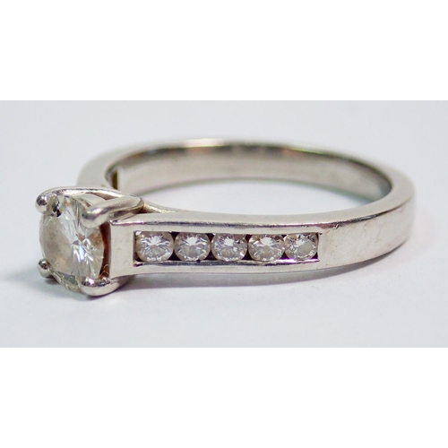 427 - A platinum ring set central diamond flanked by ten diamonds inset to shoulders, size M, 5.5g