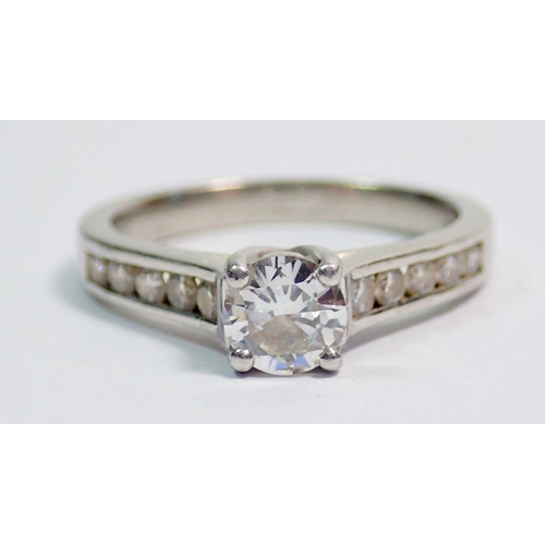 427 - A platinum ring set central diamond flanked by ten diamonds inset to shoulders, size M, 5.5g