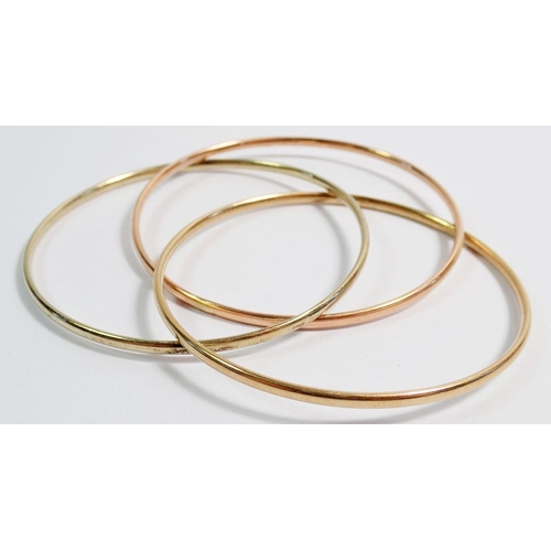 433 - A 14ct gold two colour bangle 9.7g and three triple yellow metal bangles 10g