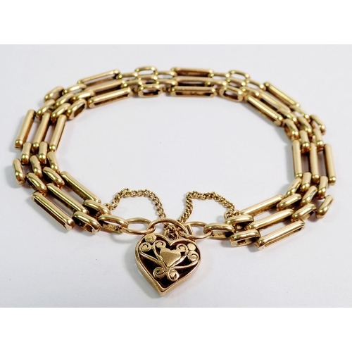 434 - A 9 carat gold gatelink bracelet with pierced heart locket, 18g