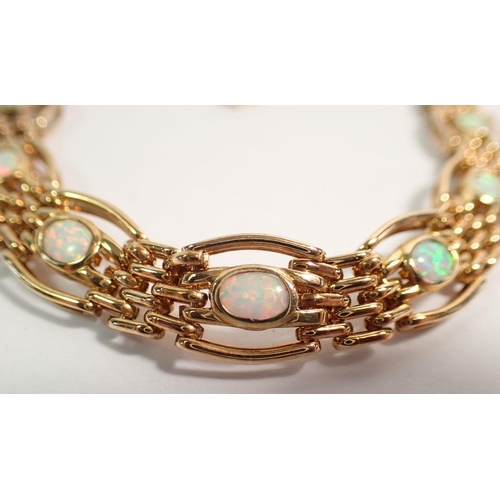 437 - A 9 carat gold gatelink bracelet set opals, 23.5g