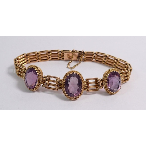 438 - A 9 carat gold gatelink bracelet set three oval cut amethysts, 20g