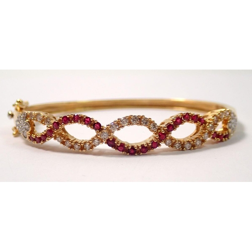 439 - An 18 carat gold hinged bangle with a braided design set diamonds and rubies, 22g