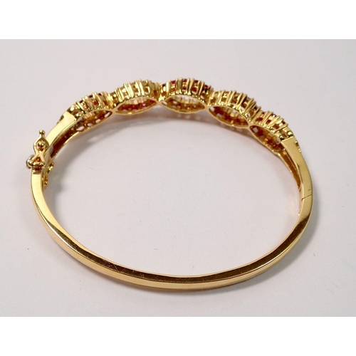 439 - An 18 carat gold hinged bangle with a braided design set diamonds and rubies, 22g