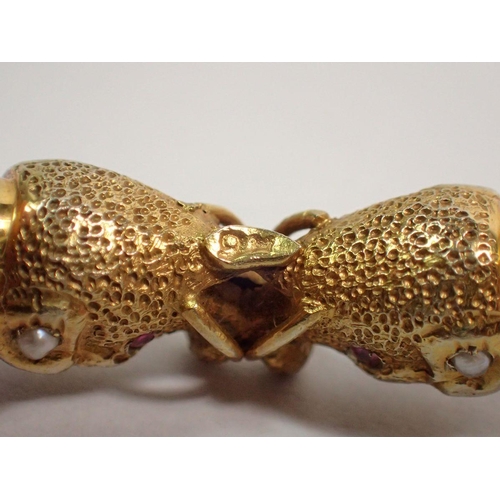 442 - A 9 carat gold Eastern pierced hinged bangle with elephant head terminals set semi precious stones, ... 