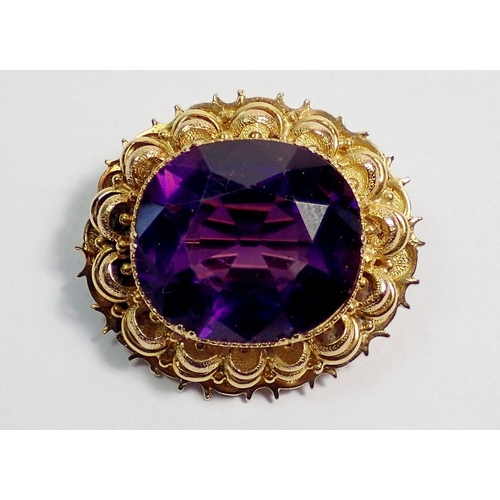 451 - A 9 carat gold oval brooch set purple stone, 2.8 x 2.5cm, 9.3g