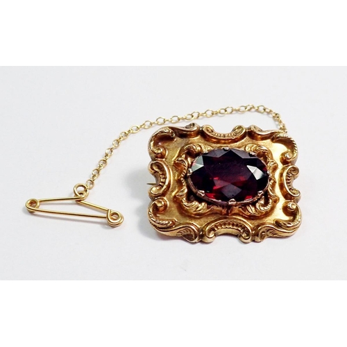 455 - A Victorian 9 carat gold brooch set garnet within scrollwork surround, 2.5 x 2cm, 4.7g