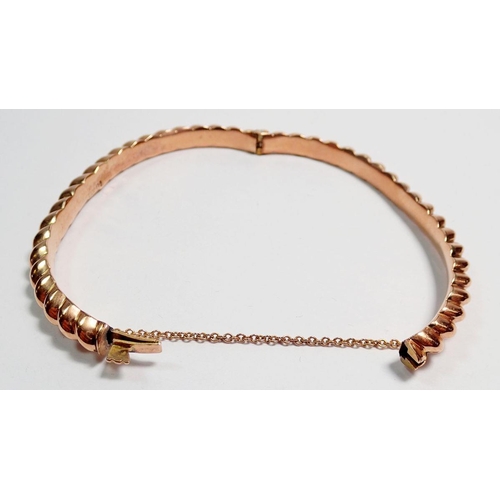 461 - A 9 carat rose gold spiral bangle, boxed, 7.2g