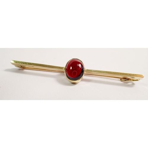 484 - A 15 carat gold bar brooch set cabochon cut garnet, 6cm, 4.5g