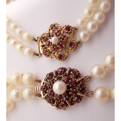 486 - A two strand pearl necklace and similar bracelet, both with 14 carat gold clasps set garnets, neckla... 