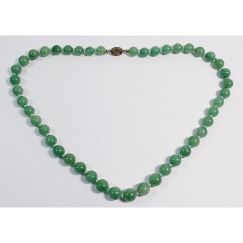 513 - A string of jade beads with silver clasp