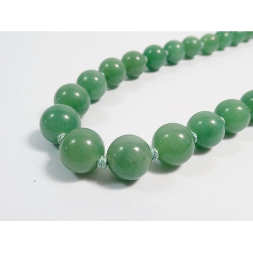 513 - A string of jade beads with silver clasp